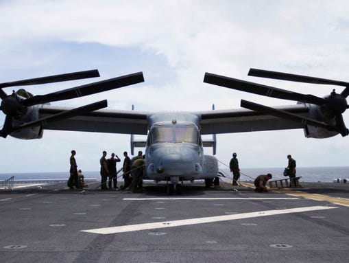 Crews perform maintenance aboard the flight deck of