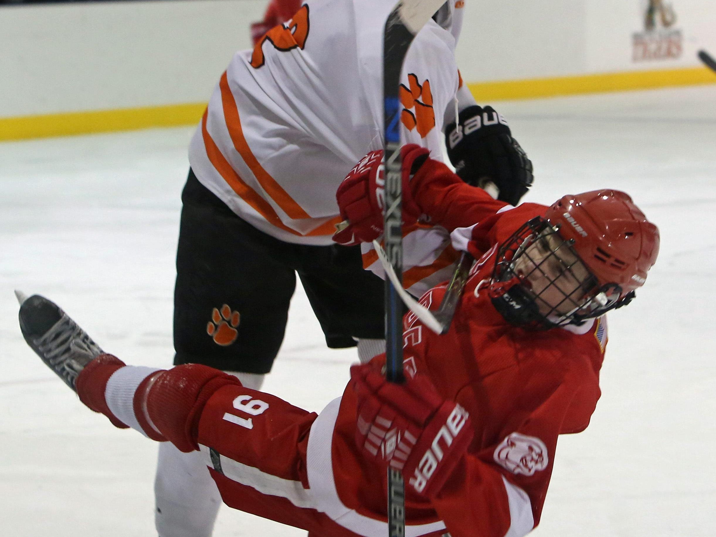 White Plains’ James Garnett hits North Rockland’s Chris Hilliard during a game at Ebersole Ice Rink in White Plains on Thursday. The teams skated to a 4-4 tie.