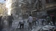 Syrian civilians and rescuers gather at the site of