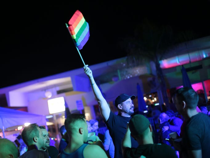 Paul Sprague of San Diego waves the Rainbow flag during