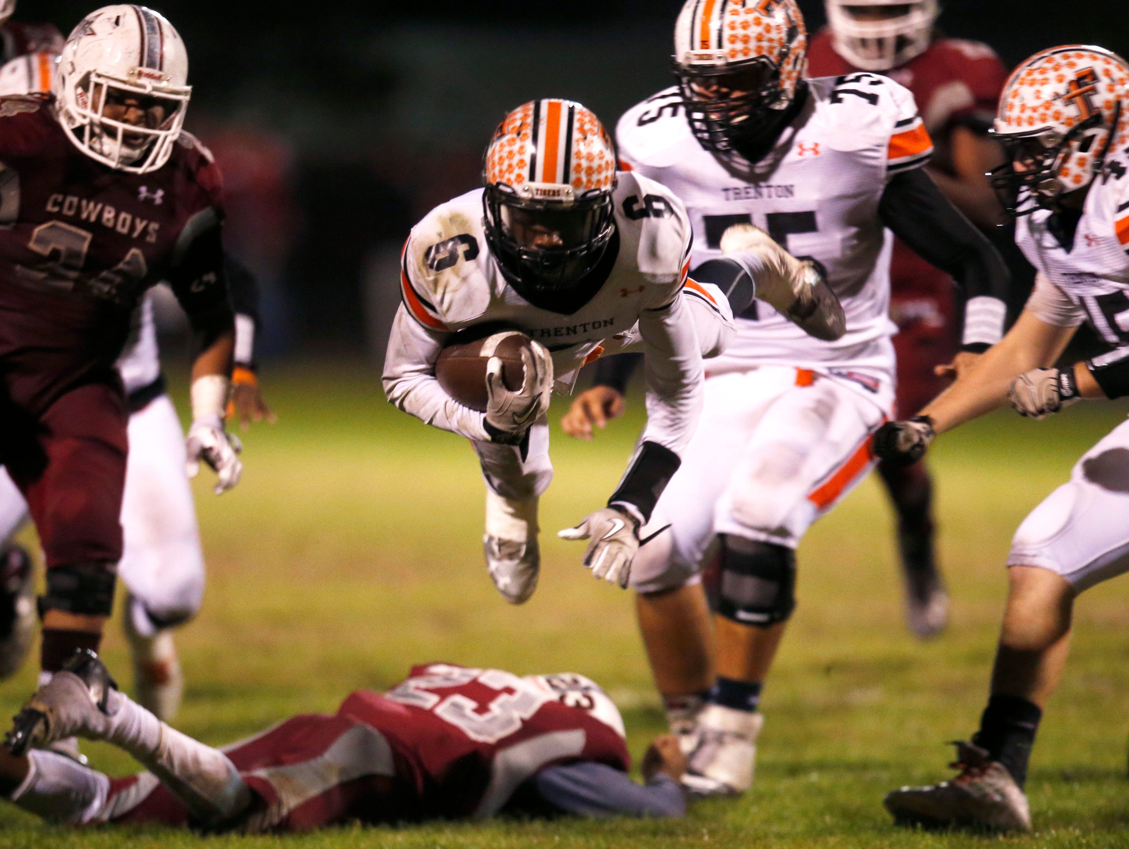 Trenton's Montrez Jackson dives forwards after being tackled by Madison County's Tinarus Irvine during their playoff game on Friday.