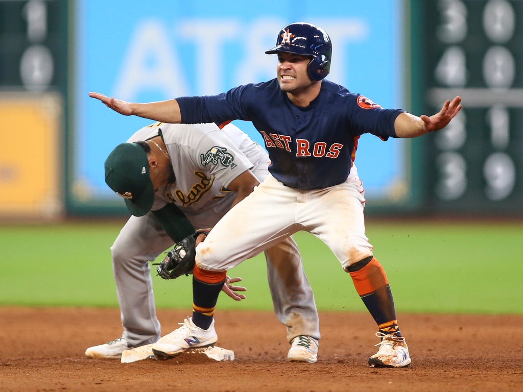 Houston Astros second baseman Jose Altuve is safe at second base with a stolen base as Oakland Athletics shortstop Marcus Semien attempts to apply a tag during the eighth inning at Minute Maid Park in Houston.