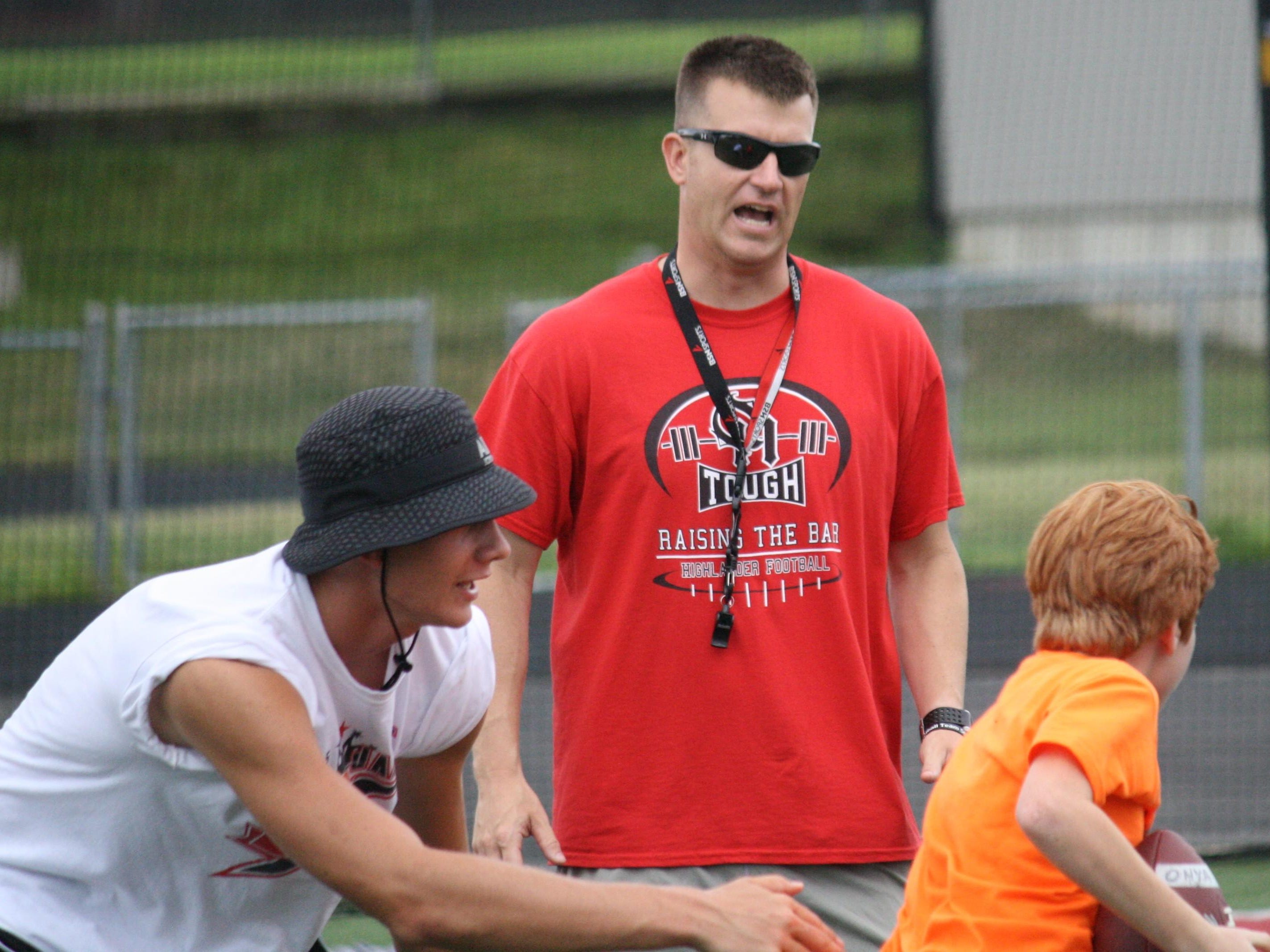 New Oak Hills football coach Evan Dreyer, middle, works during a youth football camp in June.