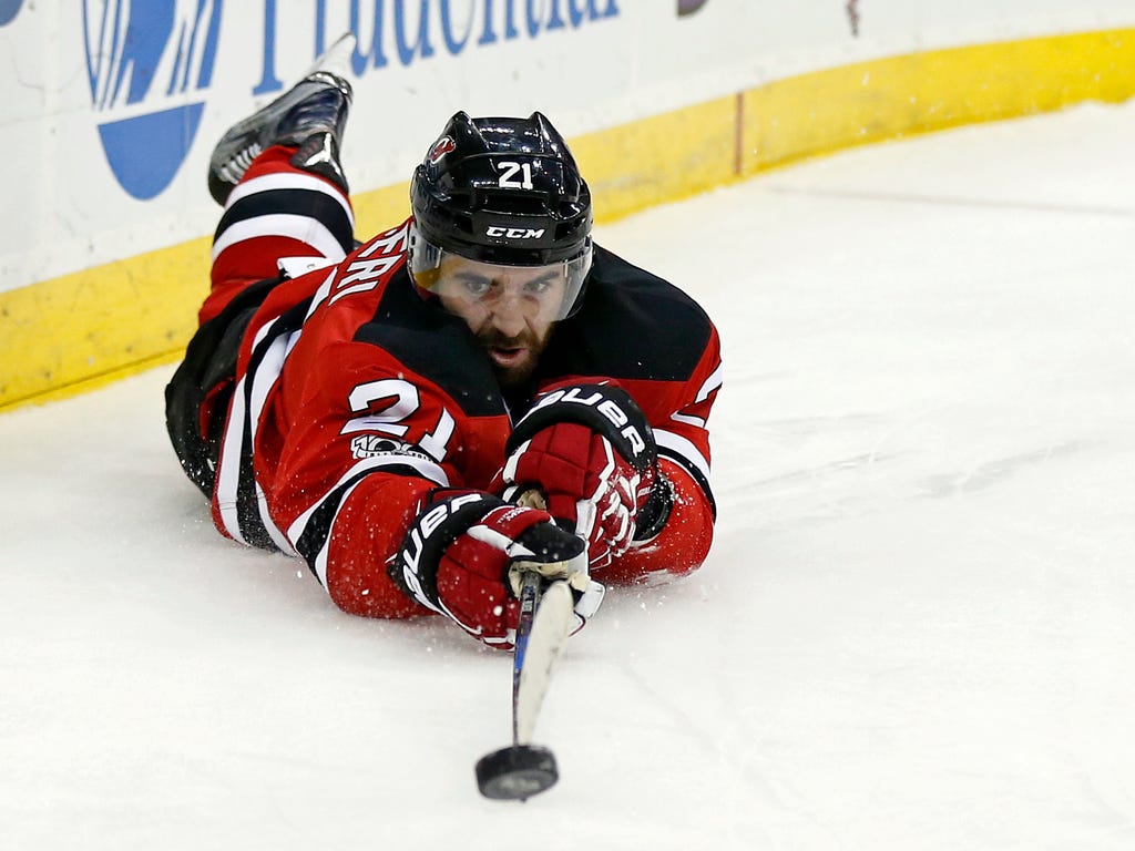 New Jersey Devils right wing Kyle Palmieri passes the puck as he falls to the ice during the second period against the Montreal Canadiens at Prudential Center in Newark.
