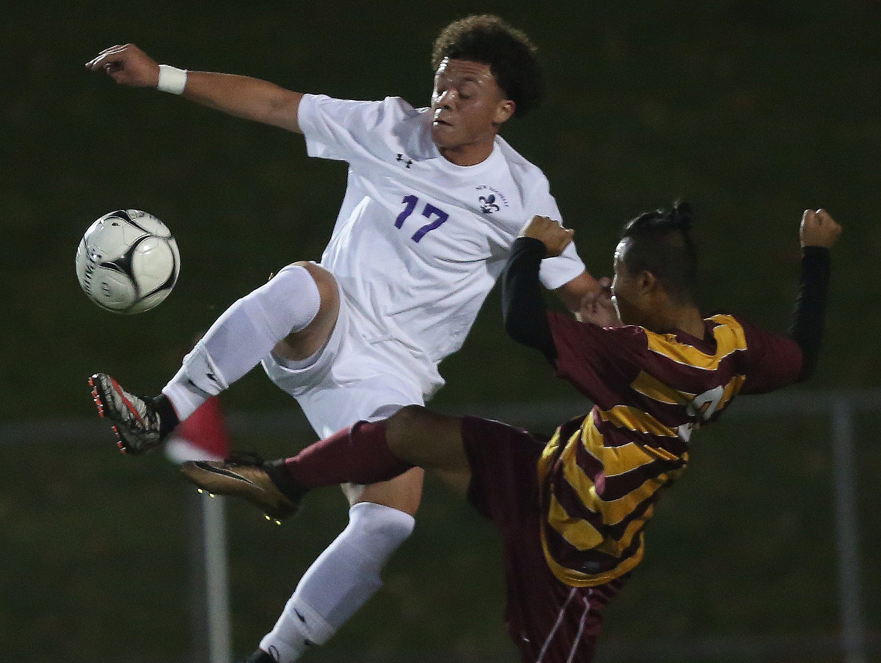 From left, New Rochelle's David Lopez (17) kicks the ball away from an Ithaca defender during the boys soccer regional semifinal at Lakeland High School in Shrub Oak Nov. 2, 2016.