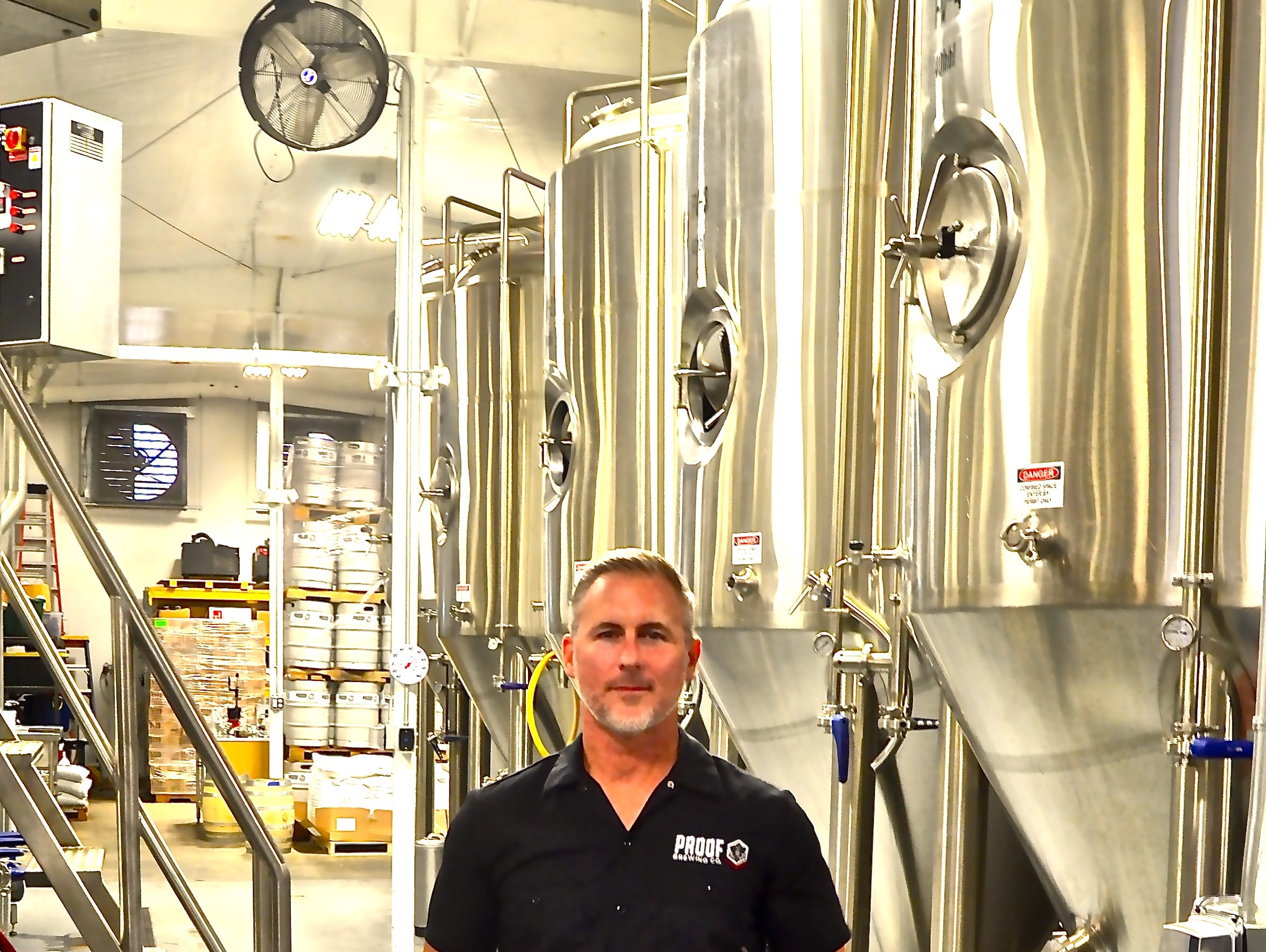 Bryan Burroughs stands amidst the brewing tanks at