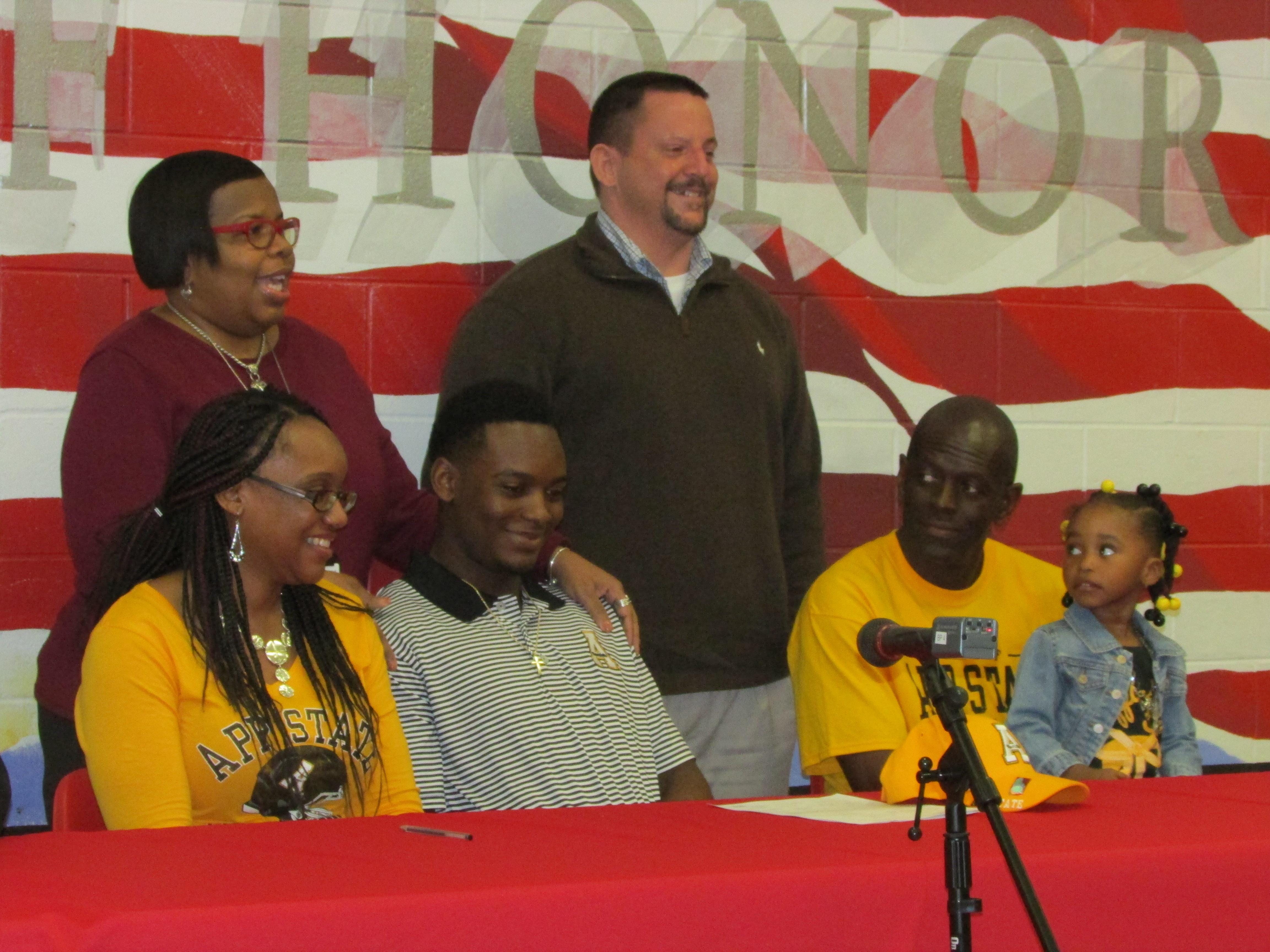West Florida’s Adarius Purifoy is joined by his parents, West Florida principal Shenna Payne and West Florida coach Harry Lees as he signed with Appalachian State.