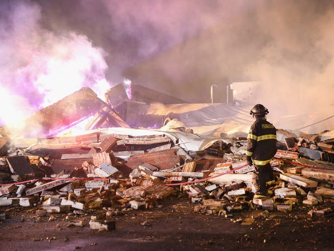 A Ferguson firefighter surveys damage to a strip mall