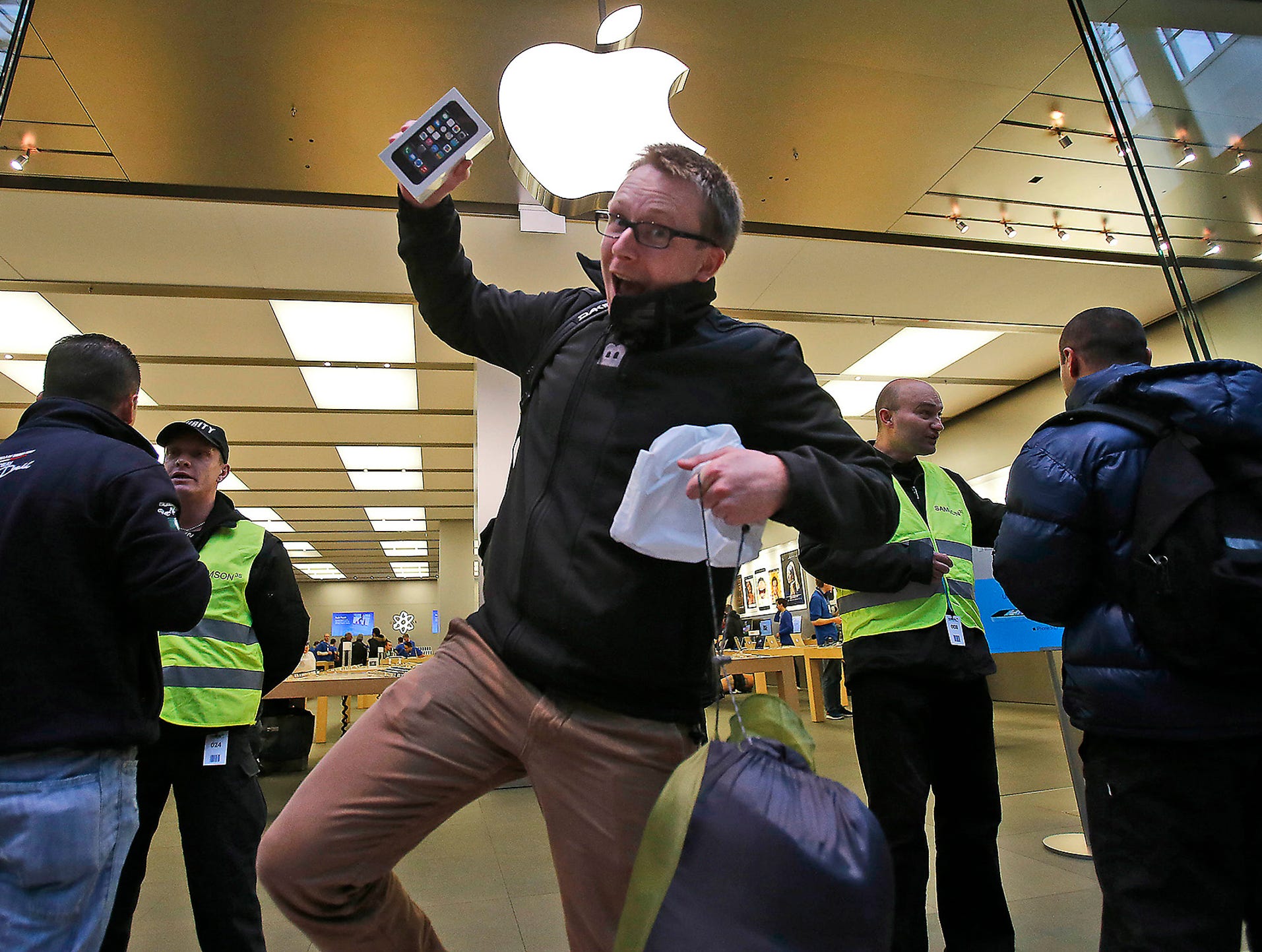 A customer celebrates his purchase of a new iPhone 5S as he leaves the Apple store on Sept. 20 in Oberhausen, Germany. The new iPhone 5s and 5C went on sale today around the world.