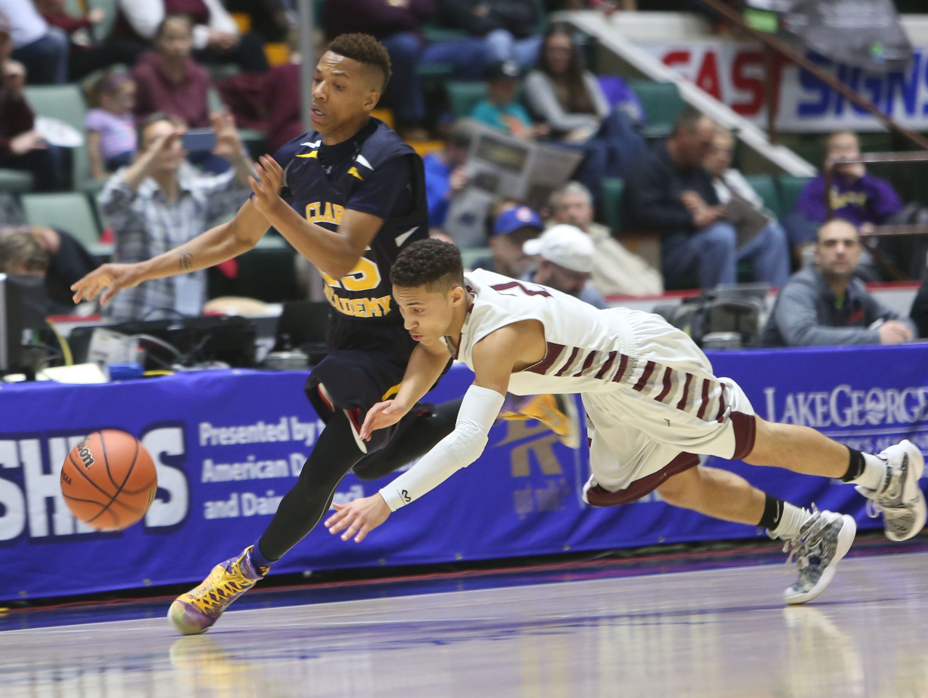 From left, Clark Academy's Andrew Carthon (25) and Oriskany's Marcus Smithing (2) battle for a loose ball during the boys Class D semifinal at the Glens Falls Civic Center March 11, 2016. Oriskany won the game 59-40.