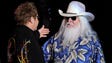 Elton John, left, greets Leon Russell on the stage