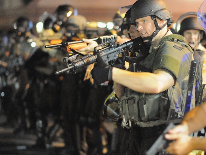 Law enforcement officers watch a protest on West Florissant Avenue in Ferguson.