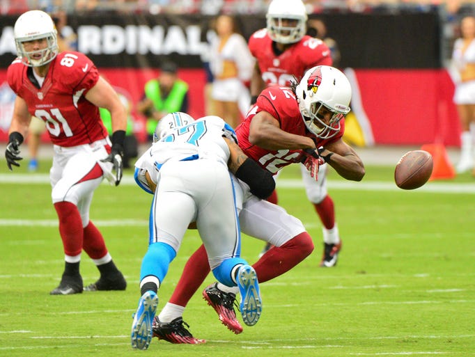 Arizona Cardinals wide receiver Andre Roberts drops the ball while being hit by Detroit Lions strong safety Glover Quin in the first half.