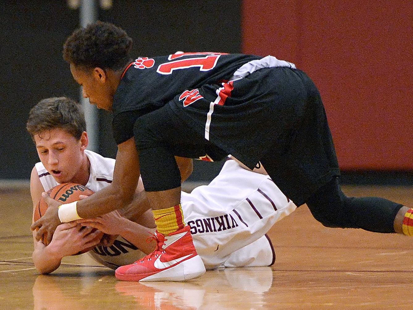Pittsford Mendon’s Jeremy Jacob, left, and Wilson’s Robert Davis fight for possession during Wednesday’s game at Pittsford Mendon High School. Wilson won 66-52.