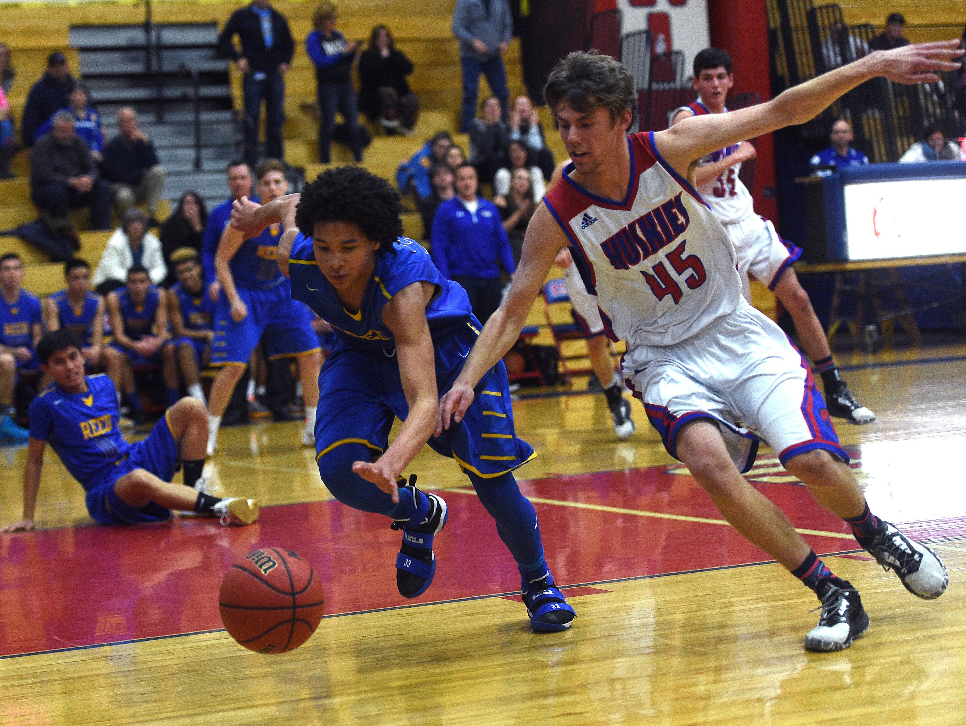 Reno's Thomas Beach (45) and Reed's Matthew Williams (33) fight for a loose ball during their basketball game in Reno on Friday.