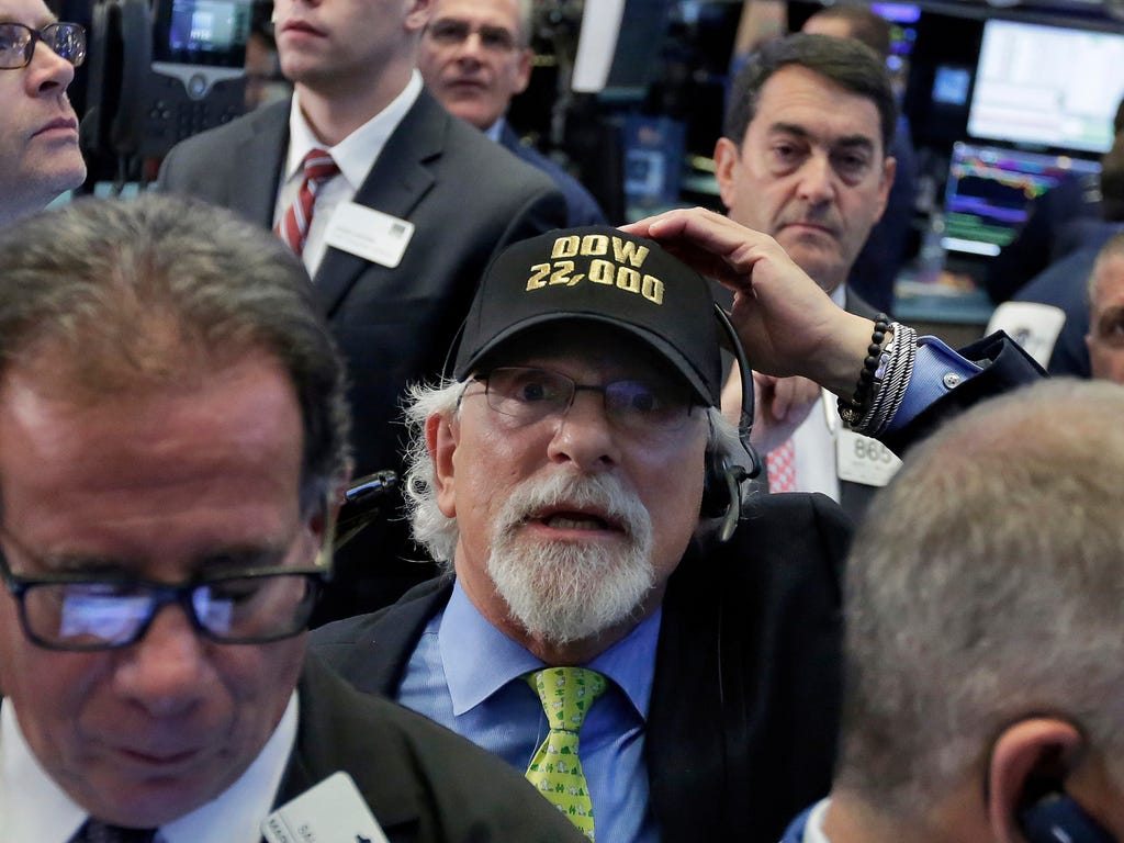 Trader Peter Tuchman, center, wears a 'Dow 22,000' hat as he works on the floor of the New York Stock Exchange, Aug. 2, 2017. A big gain from Apple Wednesday morning sent the Dow Jones industrial average above 22,000 for the first time. Most other in