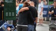 A couple embraces as they visit the scene of an explosion