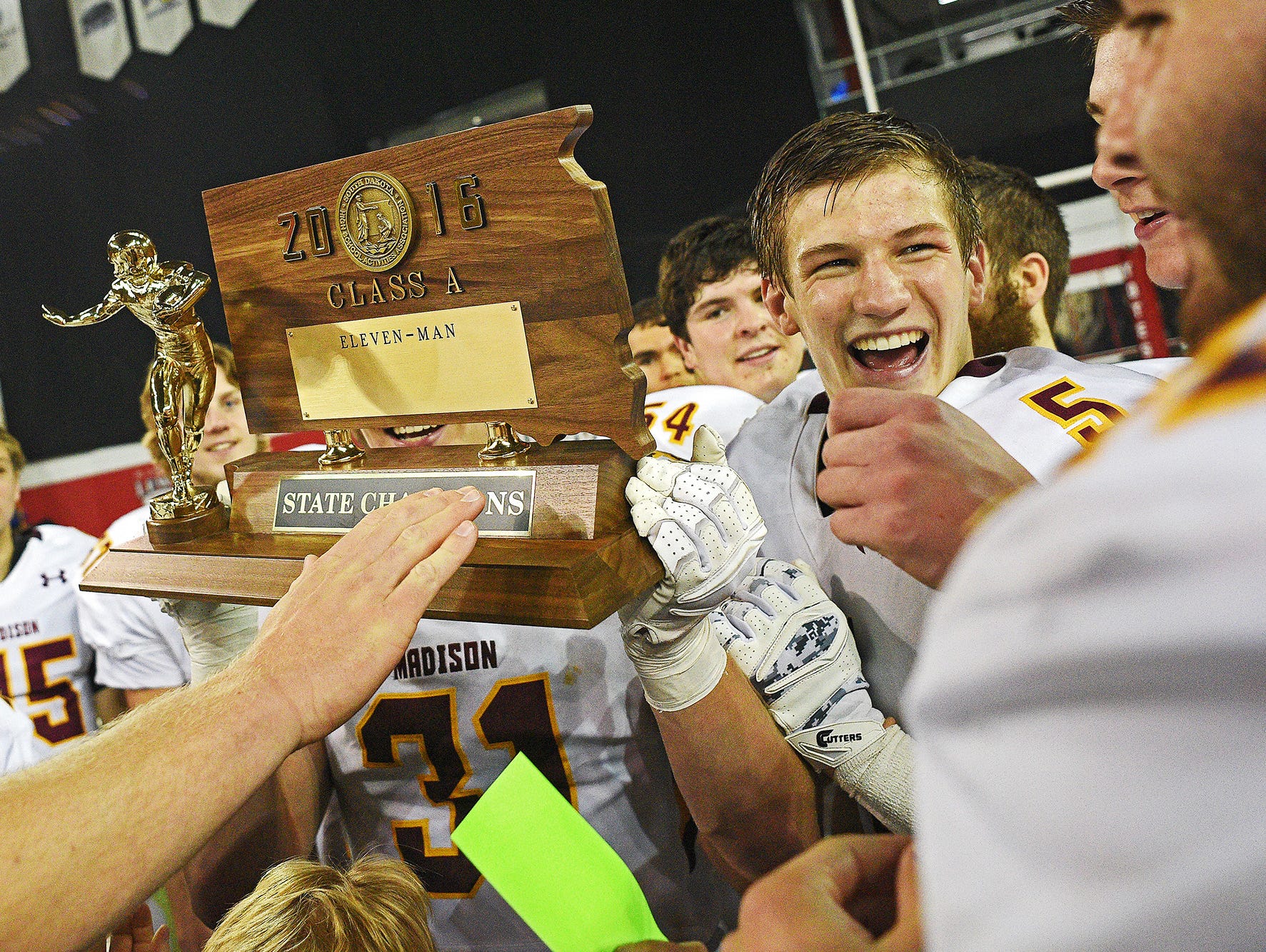 Madison's Noah Guse (5) celebrates with their trophy while celebrating their 39-0 win over Tea Area with their fans and families after the 2016 South Dakota State Class 11A Football Championship game Saturday, Nov. 12, 2016, at the DakotaDome on the University of South Dakota campus in Vermillion, S.D.