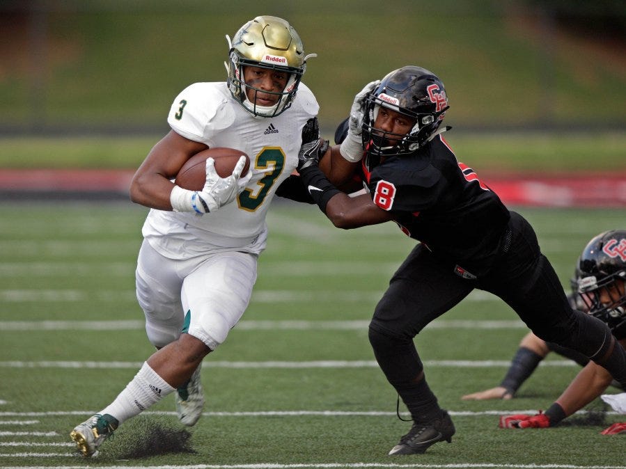 wade payne/special to the news sentinel Catholic's Amari Rodgers stiff arms Central's Edward Brodie on Friday at Central High School.