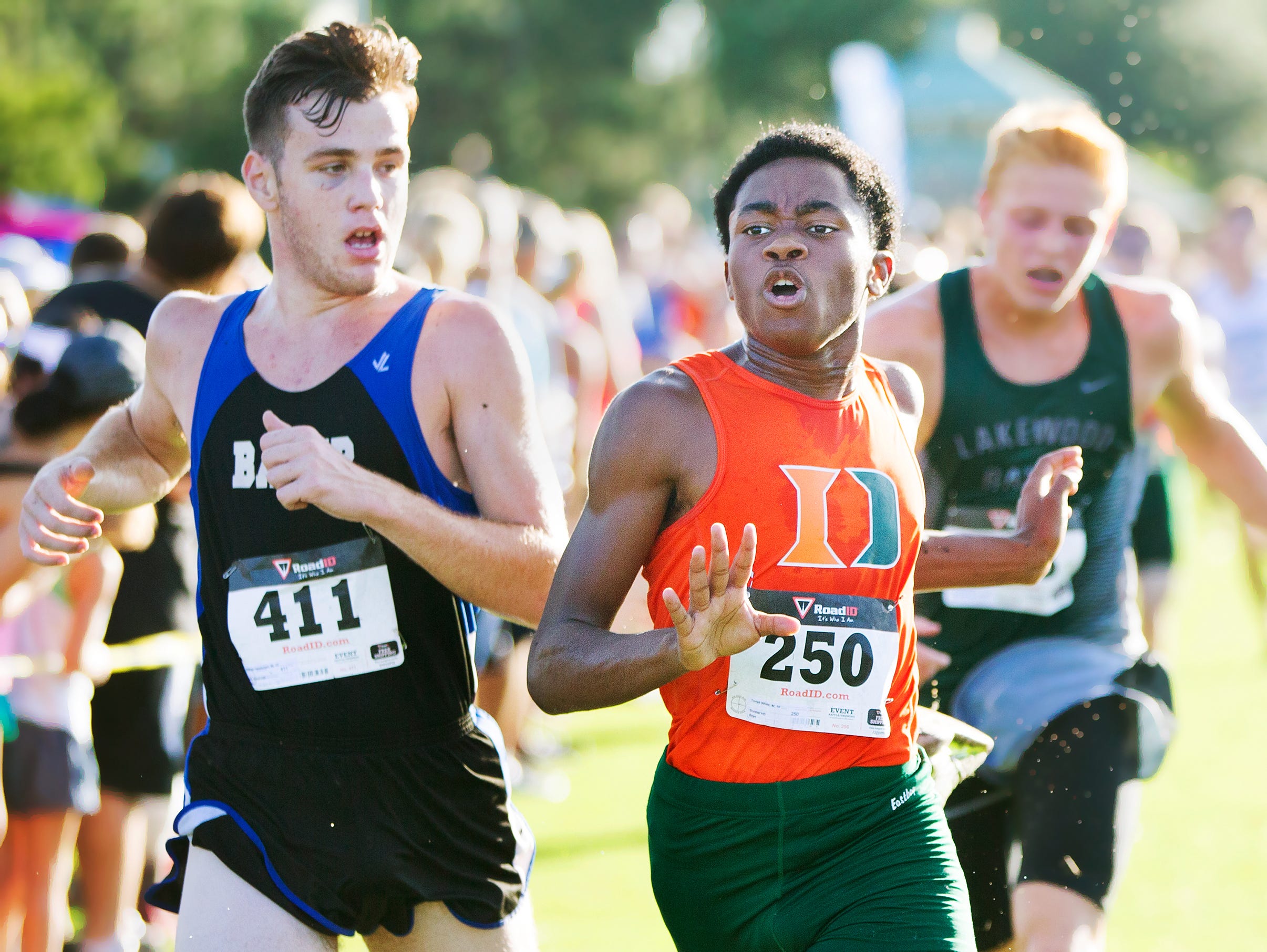 Dunbar High School's Trevor McDaniels, center, races to the finish line in the Estero DDD Invitational at Estero Community Park on Saturday. Thirty-seven high school teams from throughout South Florida competed in the annual event.