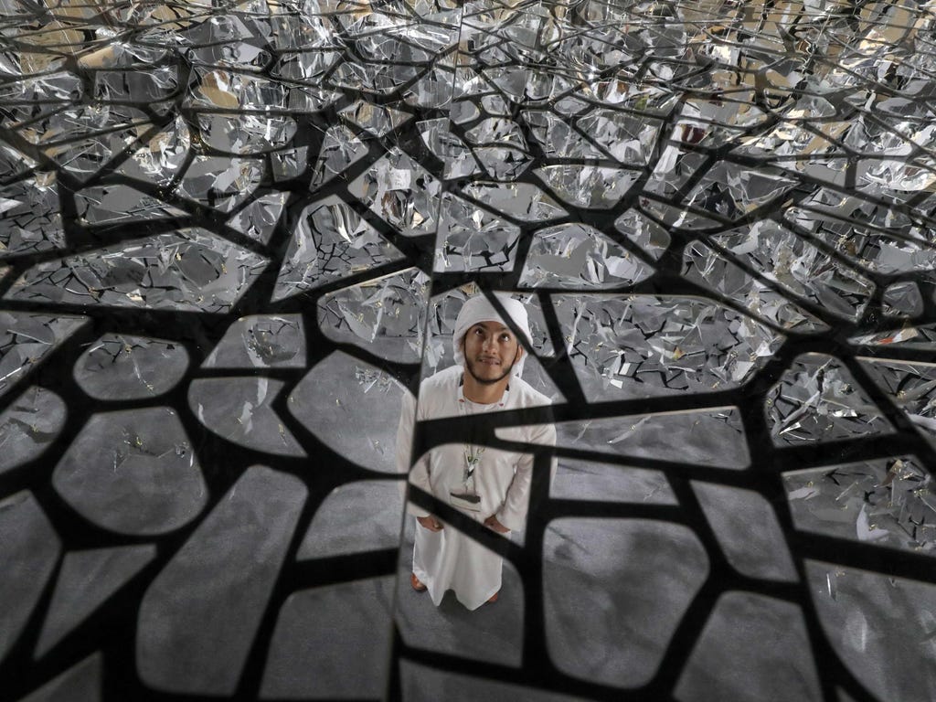 A man looks at the ceiling of a glass art installation commemorating the 2017 'Year of Giving' at the Abu Dhabi International Hunting and Equestrian exhibition. The initiative is meant to promote the culture of giving back to the community and enhanc