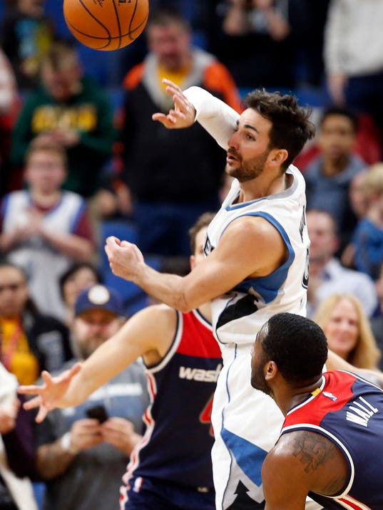Minnesota Timberwolves' Ricky Rubio, top, of Spain, passes the ball as Washington Wizards' John Wall watches during the second half of an NBA basketball game Monday, March 13, 2017, in Minneapolis. The Timberwolves won 119-104. Rubio set a franchise record with 19 assists. He scored 22 points. (AP Photo/Jim Mone)