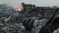 Wreckage from the airliner burns in a field.