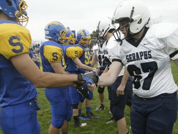Spotswood and Mater Dei football players shake hands before a game.