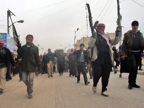 Iraqi Sunni fighters secure the funeral of a man who was killed in artillery fire in Fallujah, western Iraq, on Jan. 4, 2014.
