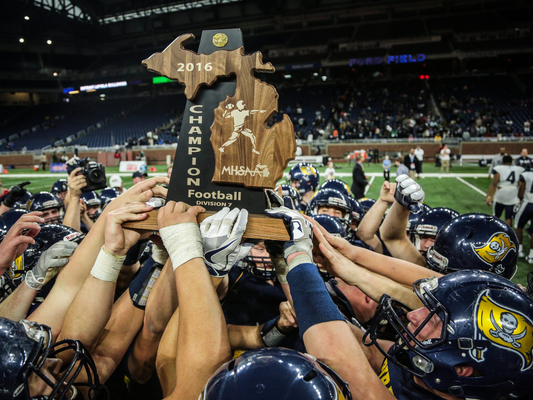 Pewamo-Westphalia's players celebrate winning the Division 7 high school title against Detroit Loyola on Saturday Nov. 26, 2016, at Ford Field in Detroit.