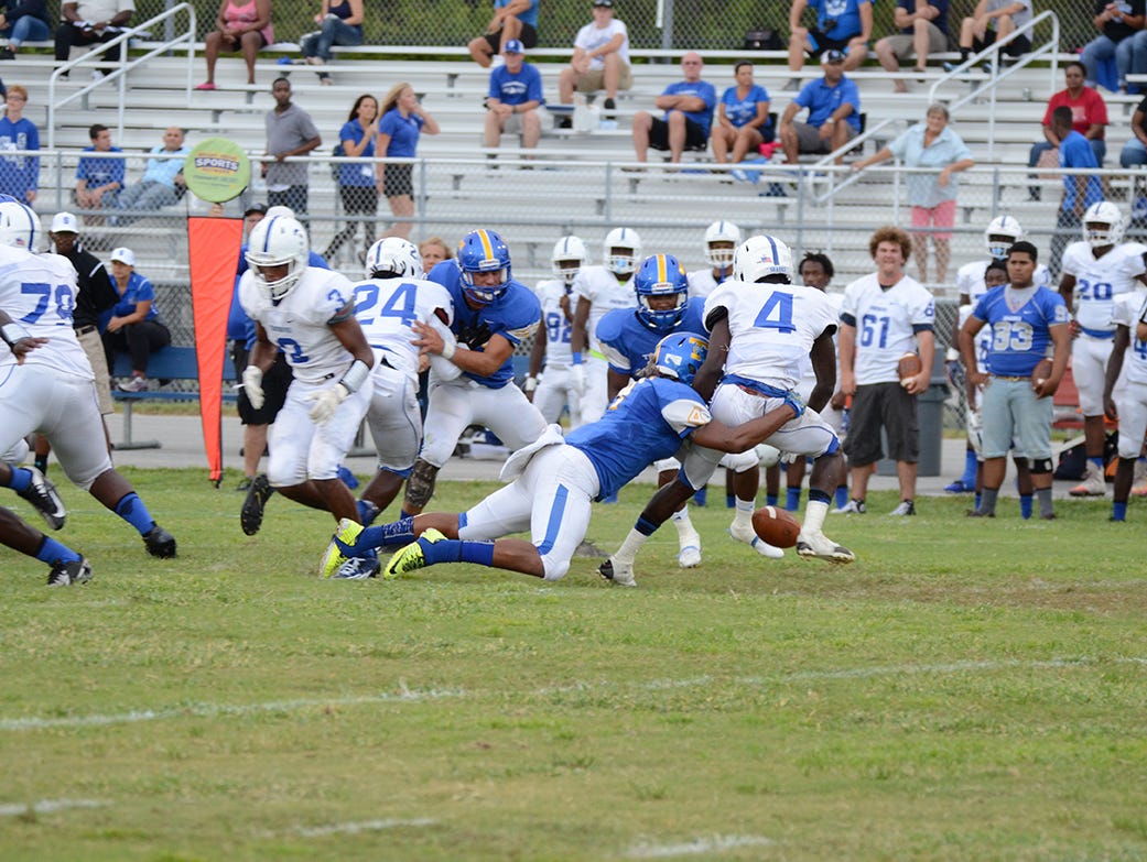 Bobby Bruce of Titusville causes Danuel Oscar of Sebastian River to fumble the ball two weeks ago at Titusville. (photo by Tony Dees/Florida Today)