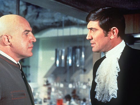 Telly Savalas, left, with George Lazenby as James Bond in 