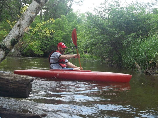 A kayaker moves down the Pine River.