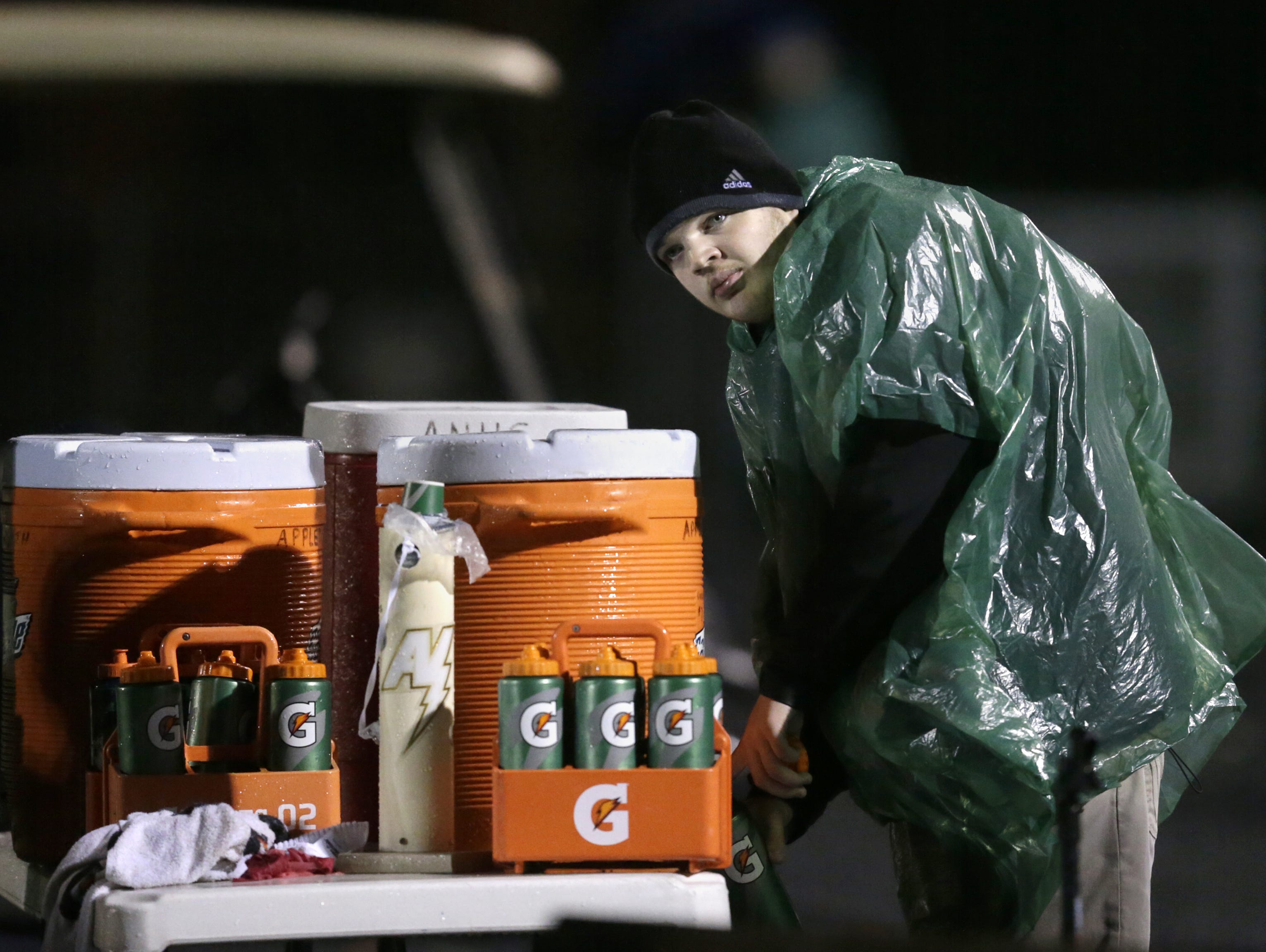 Will Carroll, an Appleton North High School football manager, fills up water bottles during North's game last week against Appleton West.