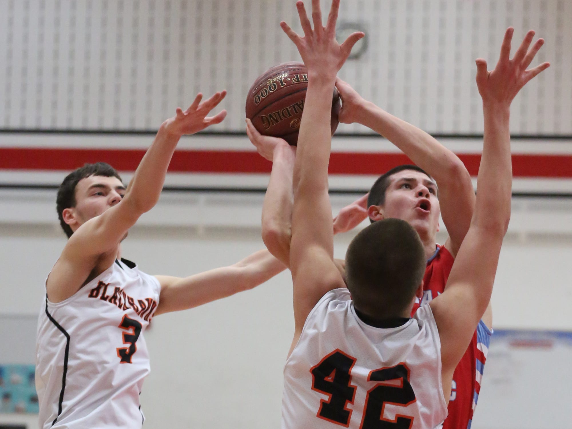 Newman Catholic's Jake Gajewski goes up for shot between Port Edwards' defenders Jake Schraeder, left, and Jared Joslin as the Cardinals lost to the Blackhawks in a WIAA Division 5 sectional semifinal at Wausau East Thursday.