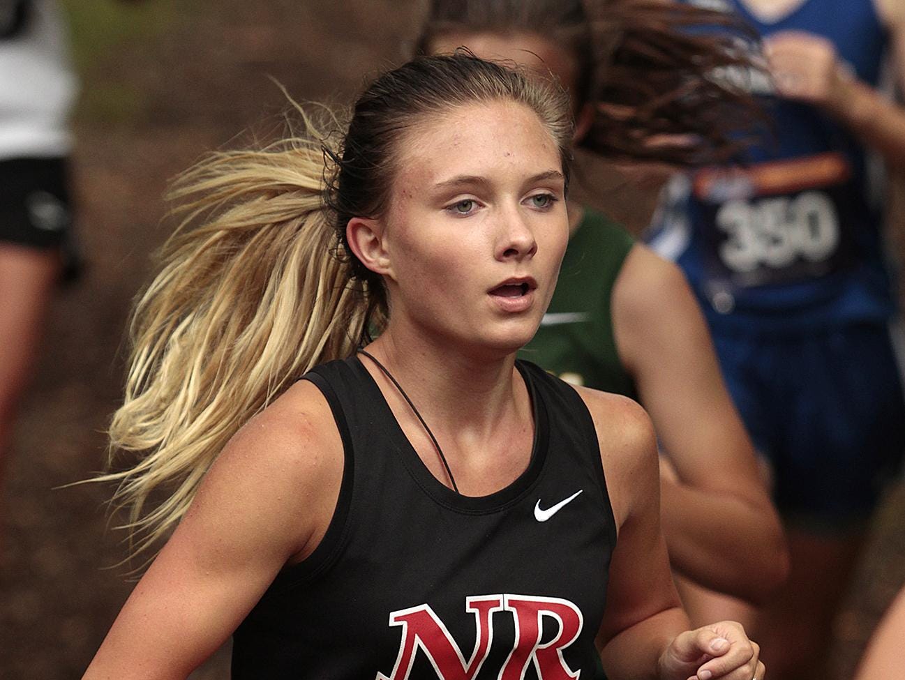 Melissa Lefler of New Richmond runs with the pack in the woods at Corwin Nixon Park Sept. 12.