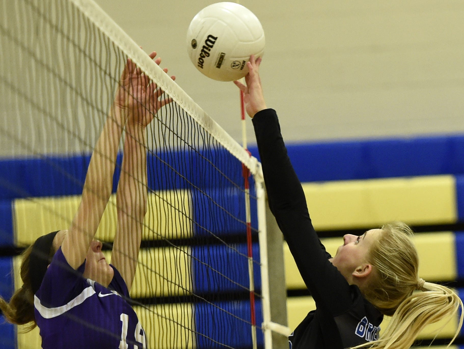 Portland High freshman Marlayna Bullington (19) and Brentwood senior Anna Wilson battle to win a point at the net during Thursday evening's sectional match.