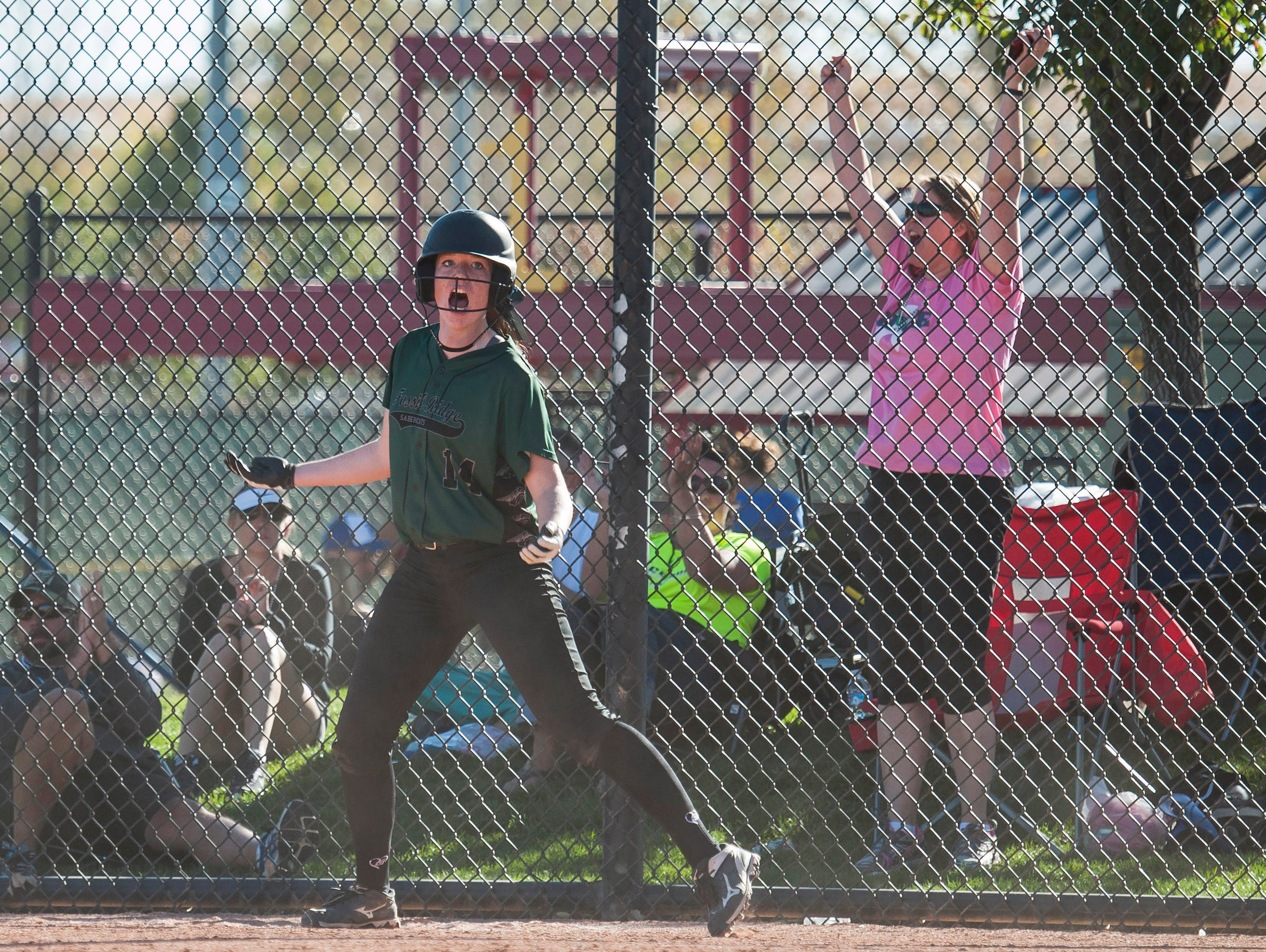 Fossil Ridge High School sophomore Kristen Reed (14) celebrates scoring a run in the game against Loveland High School in the quarterfinal round of the CHSAA 5A state softball championships Friday, Oct 21, 2016 at Aurora Sports Park. Fossil Ridge won 6-3.