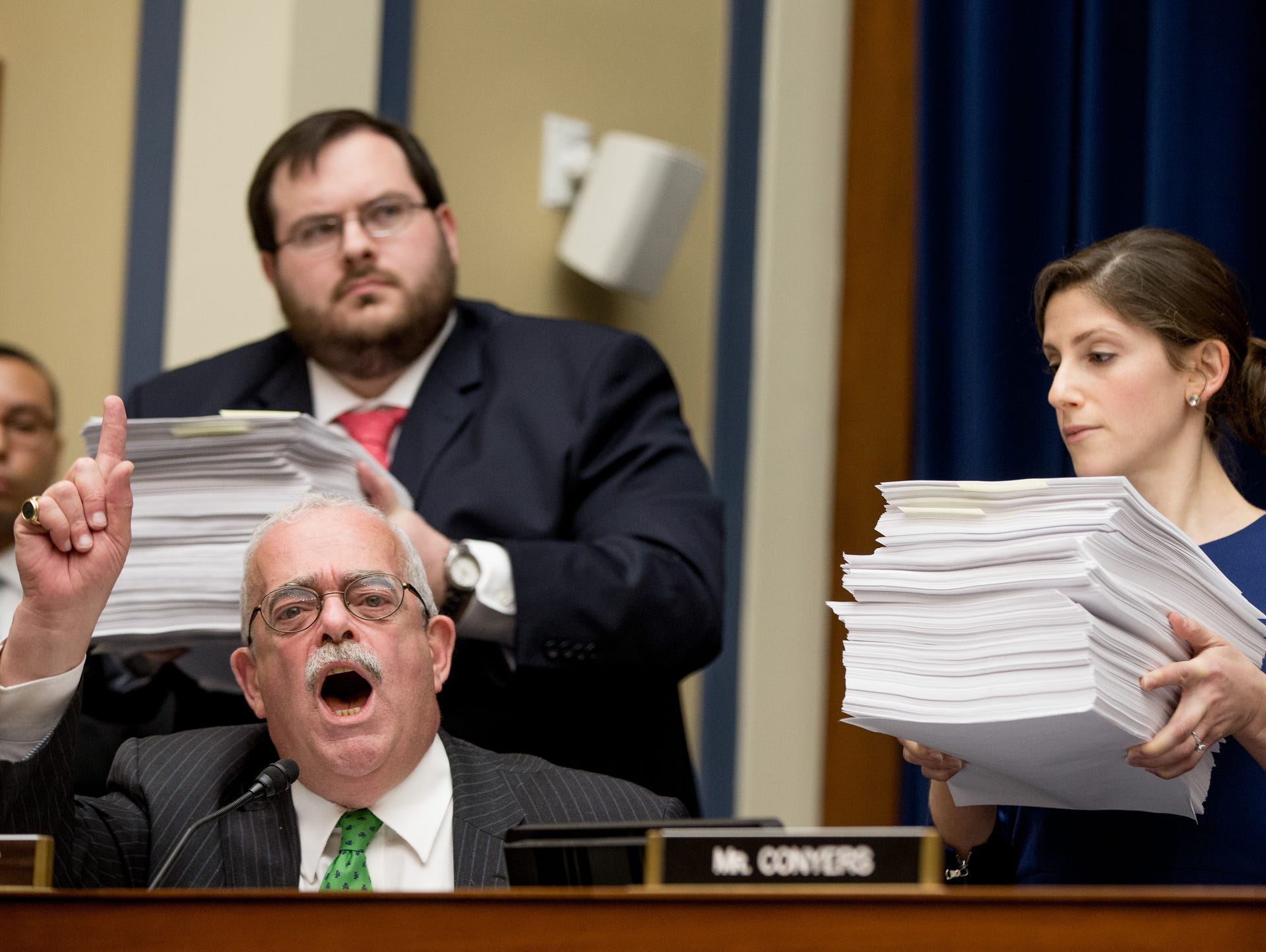 Staff members hold up stacks of emergency manager edicts