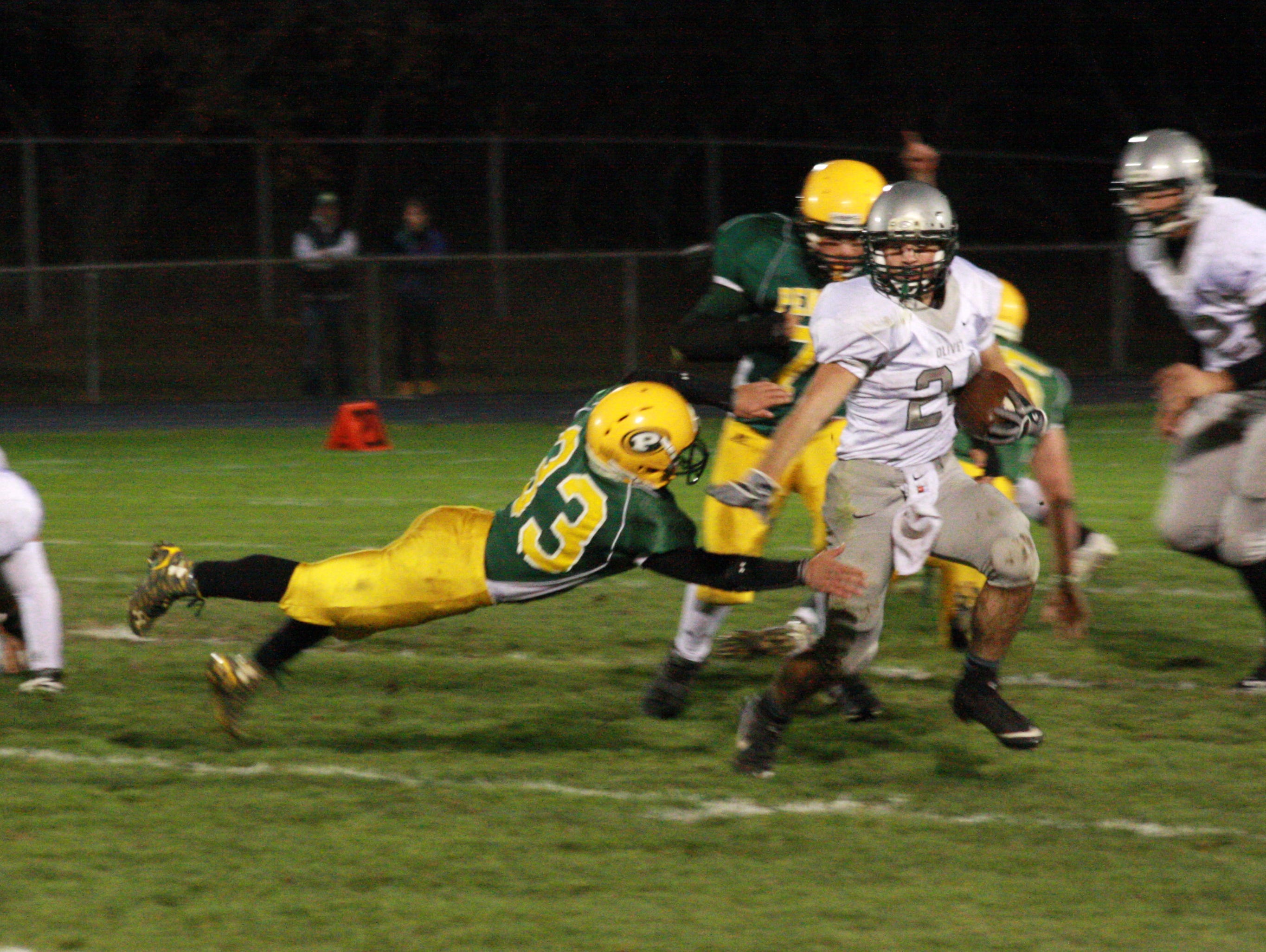 Olivet High School Senior, Chase Martin runs past Pennfield defender, Michael Davis, to score a touchdown during Friday night's game at Pennfield High School