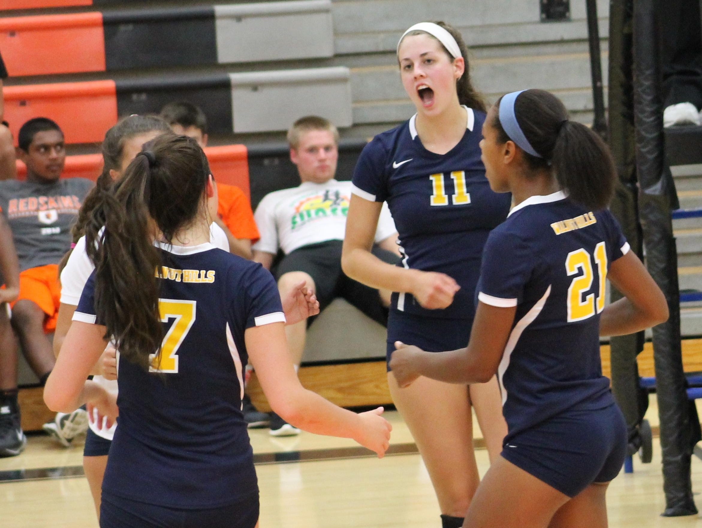 Walnut Hills junior Meredith Shaw leads the celebration after a point with senior Gabrielle Beyrer (7) and senior Janice Donaldson (21).