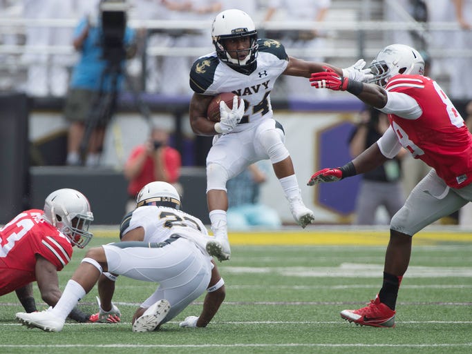 Navy running back Ryan Williams-Jenkins (24) leaps past Ohio State defenders.