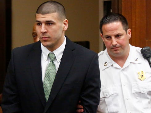 Former New England Patriots tight end Aaron Hernandez is led into the courtroom to be arraigned on homicide charges at Suffolk Superior Court in Boston, Wednesday, May 28, 2014.