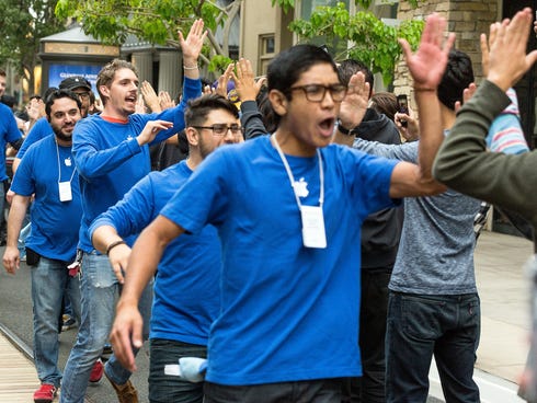 Apple sales associates cheer customers waiting in line for the latest versions of the iPhone, before the opening day of sales of the iPhone 5s and iPhone 5C at the Apple store at the Americana at Brand mall in Glendale, Calif. on Friday.