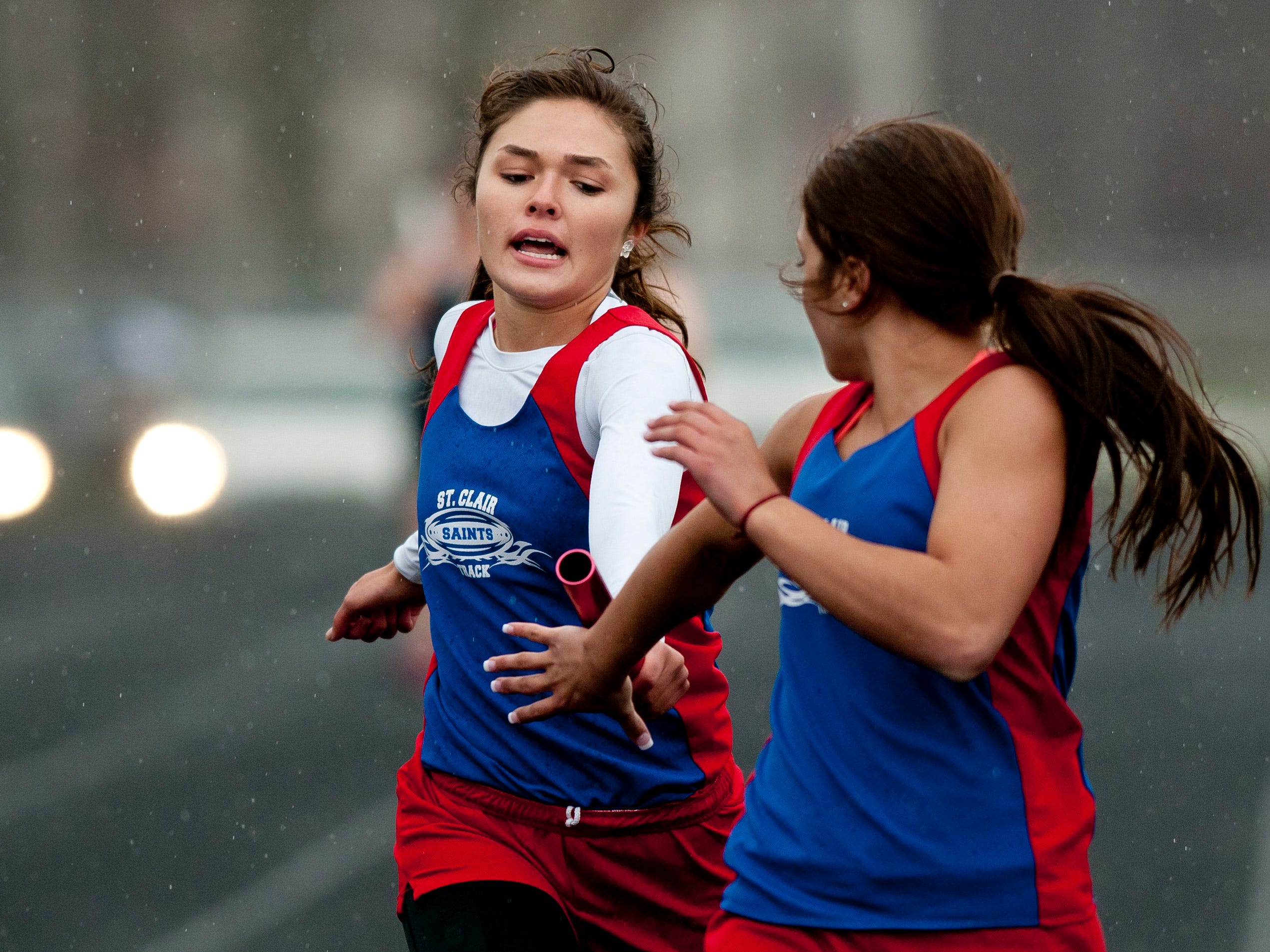 St. Clair junior Kaitlyn McLeod hands off the baton to junior Sam Jozwiak in the 4x200-meter relay during a track meet Thursday, April 30, 2015 at Marysville High School.