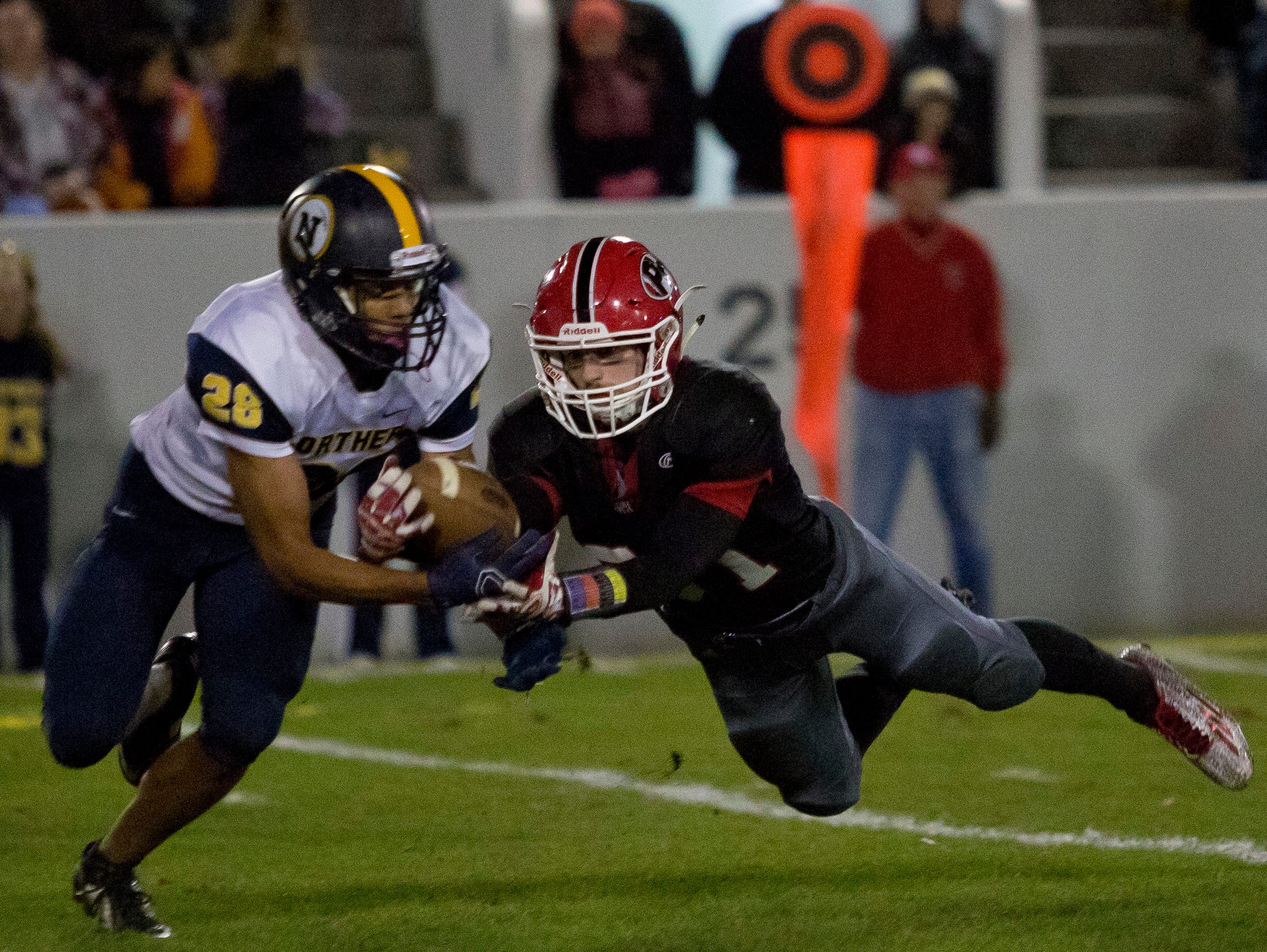 Port Huron senior Jake Lee leaps for a pass but is broken up by Port Huron Northern junior Michael Burrell during the Crosstown Showdown Friday, October 23, 2015 at Memorial Stadium in Port Huron.