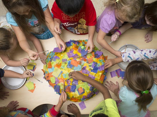 Kindergarten students make a pinata at Bright Horizons