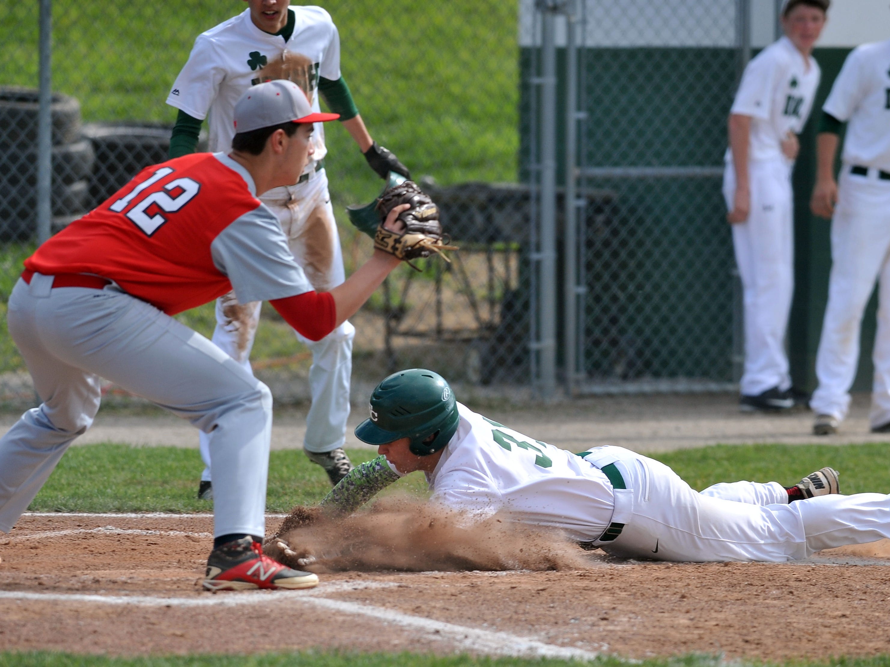 Fisher Catholic’s Blake Saffell slides safely into home Wednesday night in Lancaster. The Irish defeated Fairbanks 5-2.