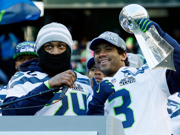 Seahawks QB Russell Wilson (3) and RB Marshawn Lynch show off the Lombardi Trophy at CenturyLink Field on Wednesday.