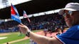 Fan holds a Cuban and American flag prior to the Tampa
